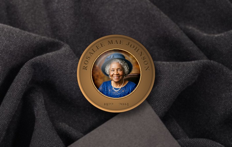 A rendered specimen of the Keeper’s Medallion — Rosalee Mae Johnson’s portrait under its clear dome, her name and years engraved in the bronze; every medallion is engraved anew